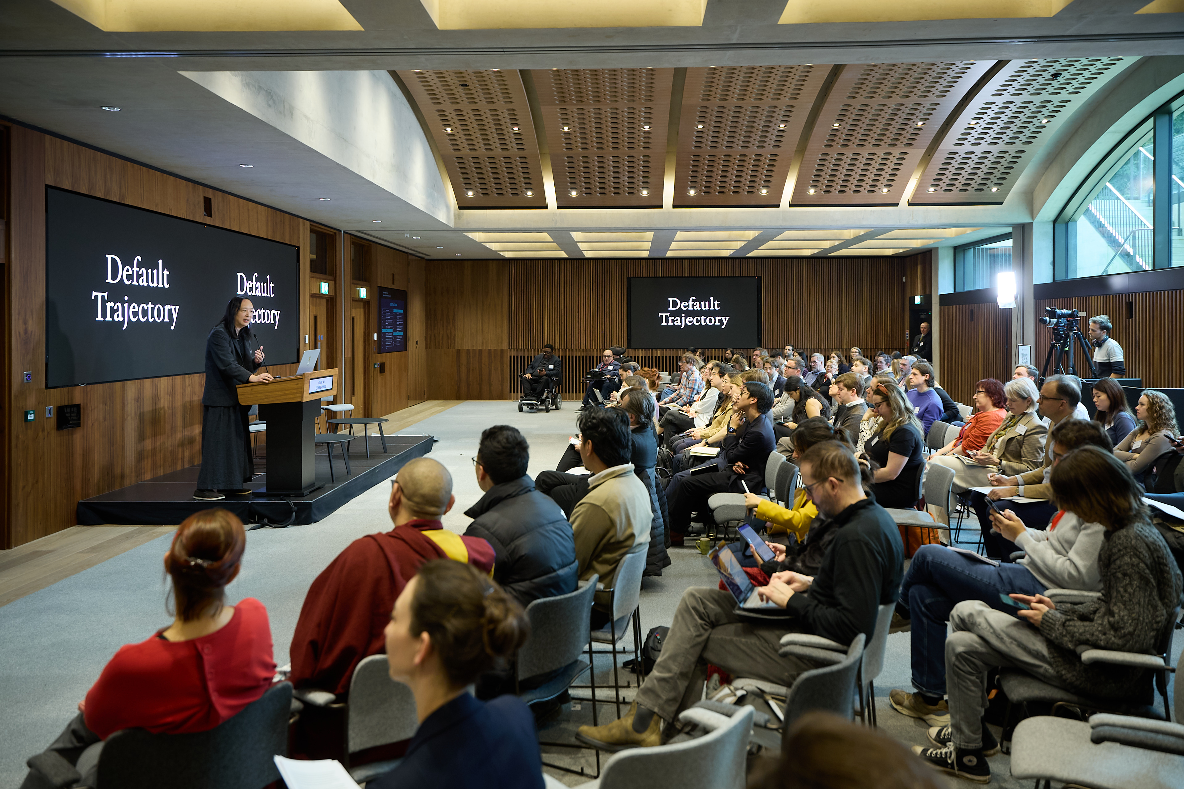 Image shows speaker and audience at the Civic AI summit event